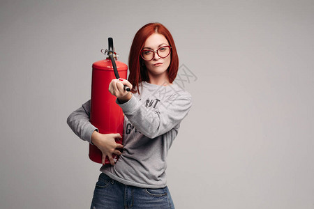 工作室里一个红头发的女人拿着灭火器一个情绪化的聪明女人用灭图片