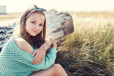 漂亮的小女孩在海边的海滩上放松图片