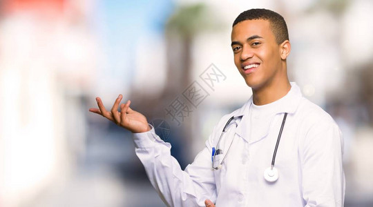年轻的美国男青年医生伸出双手站在一边邀请图片