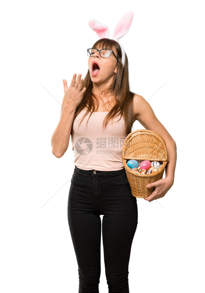 年轻女子在复活节打哈欠和用手遮住嘴唇时戴耳朵图片