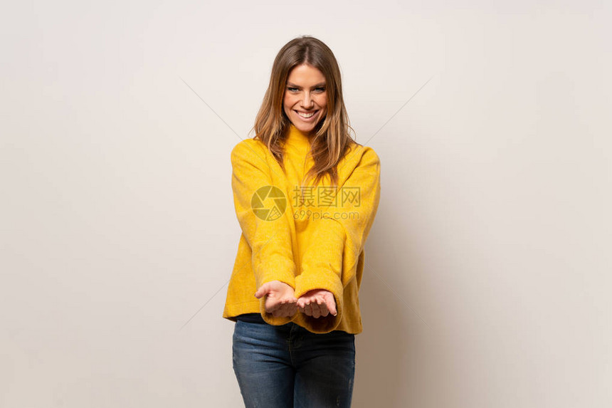 在隔绝的墙上挂有黄色毛衣的妇女手掌上想象中的复制空图片