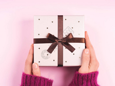 女人手拿毛衣拿着礼物盒上面有粉图片