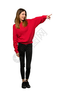 一名穿着红色毛衣的年轻女子在孤立的白色背景图片