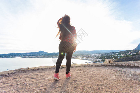 旅行旅程和航程概念年轻漂亮女人站在悬崖图片