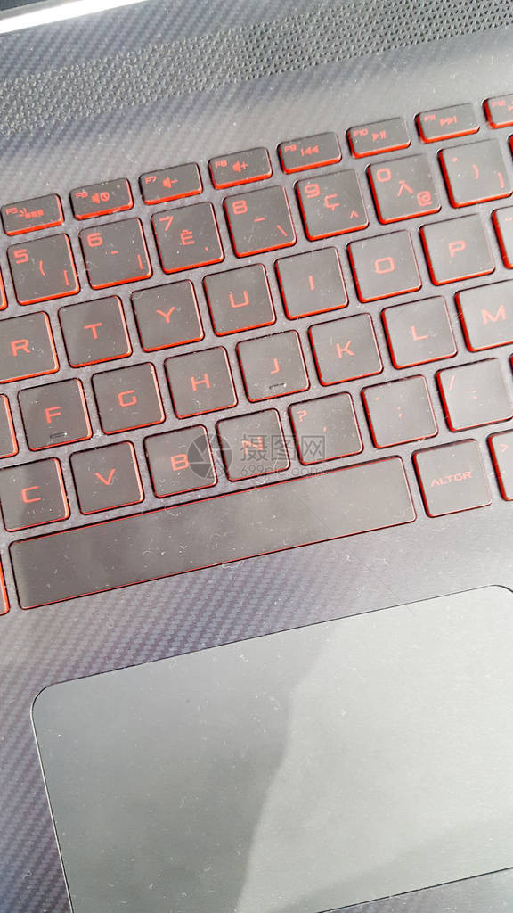 在黑暗中游戏的笔记本电脑键盘上的特写红色背光图片