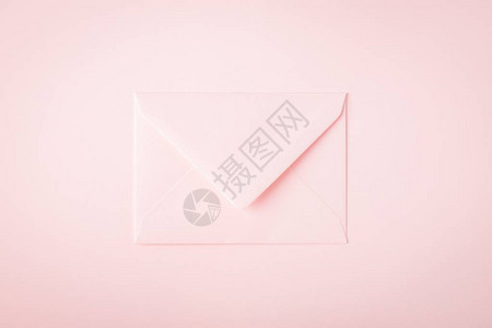粉红色背景上的浅粉色信封细腻的背景最小的概图片
