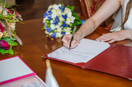 新娘在婚姻宫的结婚文件上签名图片