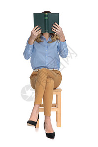坐在木椅上全身照像时穿着书本看图片