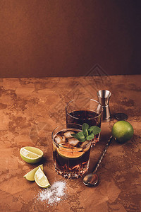 朗姆酒和可乐冰块的鸡尾酒以及深褐色底部玻璃杯子中的石灰烈酒精饮料复制空间背景图片