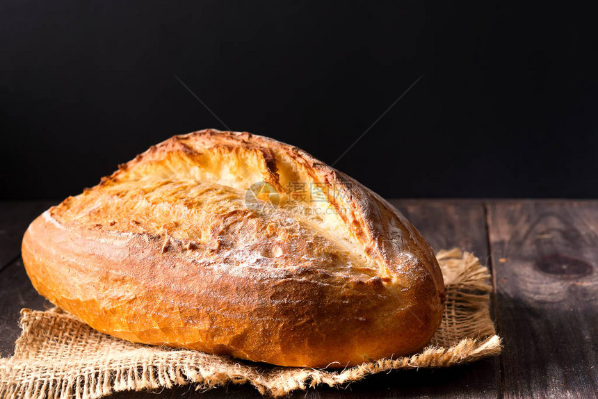 质朴的面包卷或法式面包小麦和面粉在木头上农村厨房或面包店-带有自由文图片