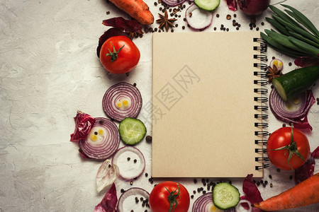 食谱笔记本店周围的新鲜蔬菜以浅薄的背景为背景图片