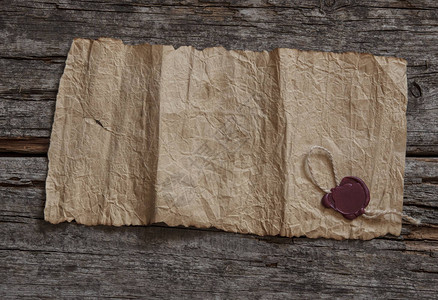 木制背景上的旧空白羊皮纸蜡封的特写背景图片