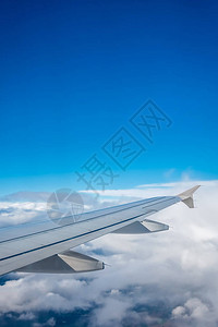 在云层之上飞行的飞机翼的窗口视图图片