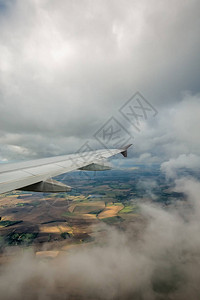 飞机在云层和英语乡村上空飞行的机图片