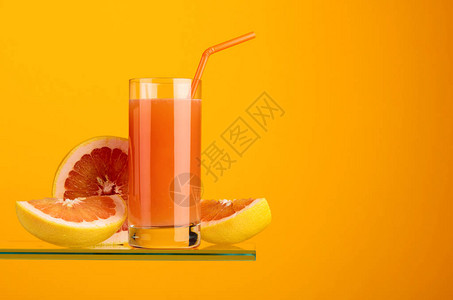 一杯新鲜葡萄果汁橙色背景的鲜果图片