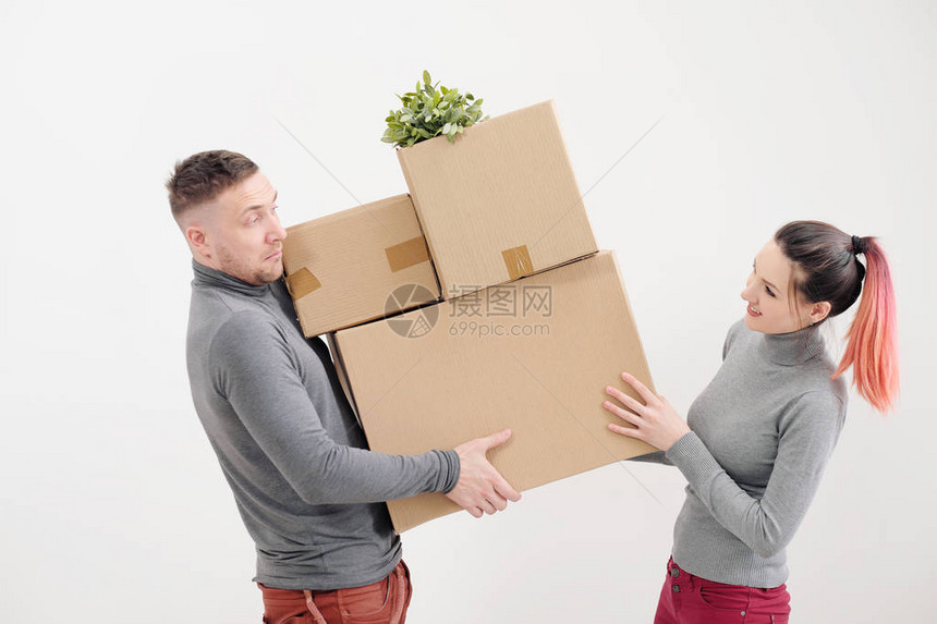 年轻女子和男子携带着重纸板箱图片