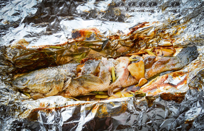 用盐酱和香草在箔食品上烤制条纹蛇头鱼图片