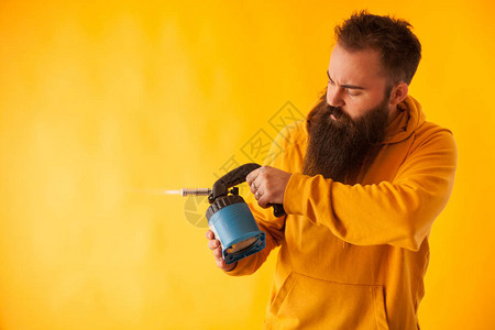 在黄色背景上举着火炬的胡子手法男子专业工具图片