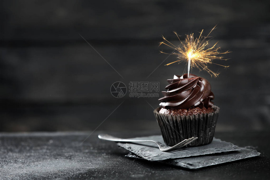 美味的生日蛋糕黑桌上放着烟火图片