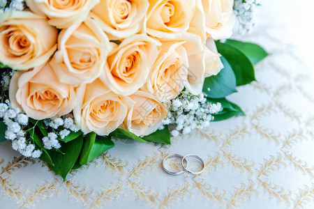 美丽的结婚戒指躺在浅色的表面上图片