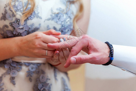 新娘和新郎的婚姻手与结婚戒指新娘手把结婚戒指放在新郎手指上爱的宣言图片