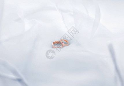 白色透明织物上的结婚戒指照片图片
