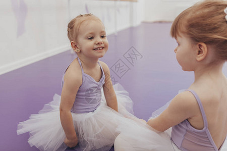 可爱快乐的小女孩在舞蹈工作室的芭蕾舞课后开心地对她的朋友微笑图片