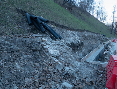 在地面铺设维修水管有沟渠和黑色波纹管的山背景图片