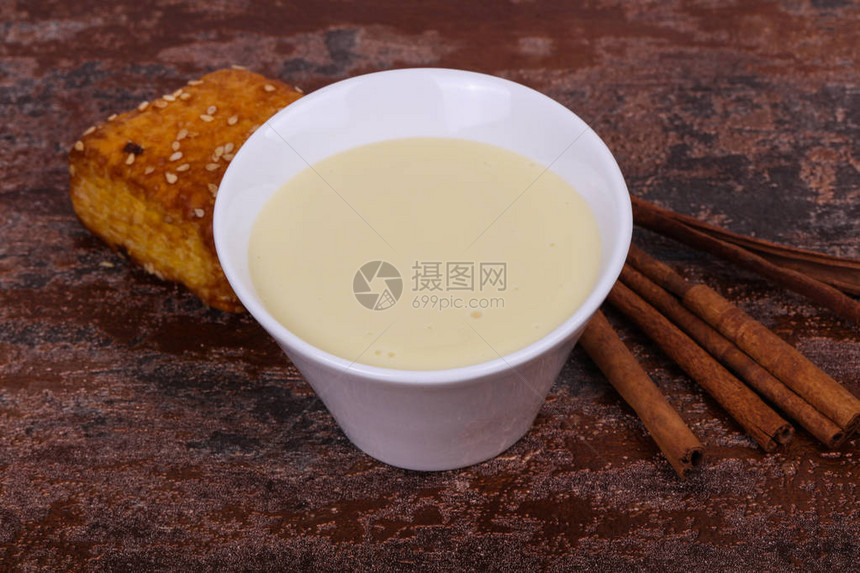 碗里的炼乳配上桂枝和糕点图片