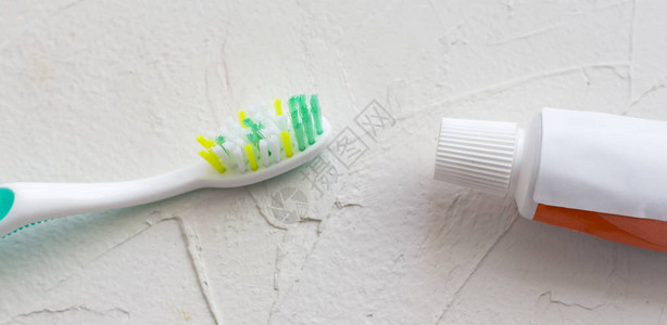 白色带纹理的背景上的牙刷和牙膏图片
