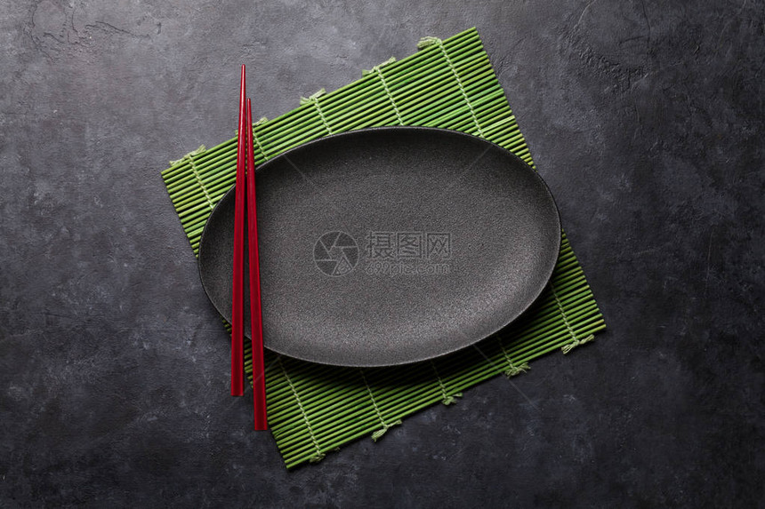 黑色纹理桌子上的空盘子和筷子图片