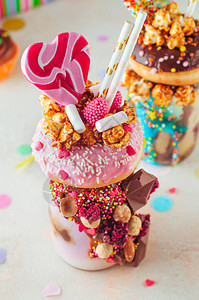 草莓怪胎用甜圈焦糖爆米花和甜点在派对背景上摇摆图片