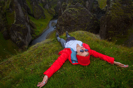 身着红色大衣的年轻女子在冰岛极美Fjadragrglj图片