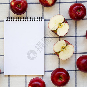 原始红色苹果和空白的笔记本图片