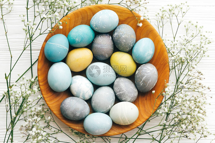 时尚的复活节彩蛋与春天的花朵在木板平躺在白色的木制背景上现代彩色复活节彩蛋涂有柔和的天然染料复活图片