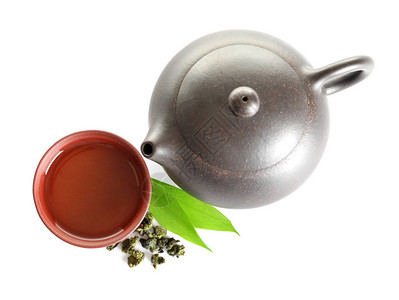 茶壶靠近铁质关燕的杯子和白色背景的叶图片