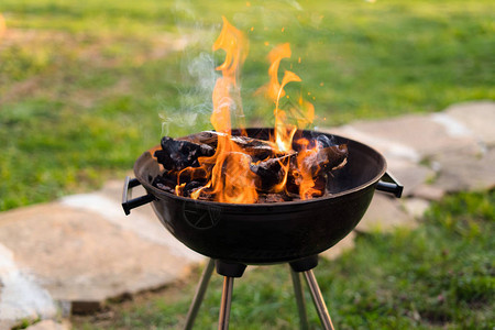 在烧烤炉中烧柴在后院准备热煤供烤肉图片