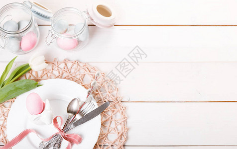 复活节餐桌设置与粉红色和蓝色鸡蛋和白色餐具假期背景背景与复制空间图片