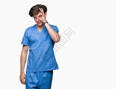 身穿医疗制服的年轻医生在与世隔绝的背景下做着很好的手势图片