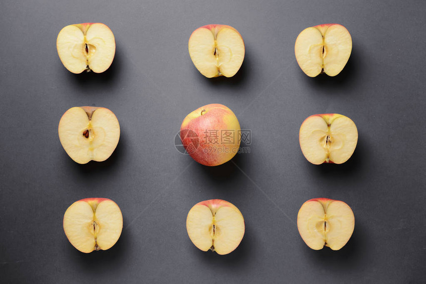在灰色背景的切苹果中一个完整的苹果图片