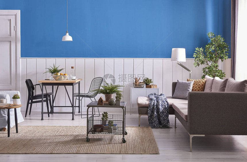 现代餐厅装饰木桌和黑色椅子蓝色和白色的墙壁背景经典的墙壁细节灰色家具中桌沙发和蓝色扶手椅柳图片