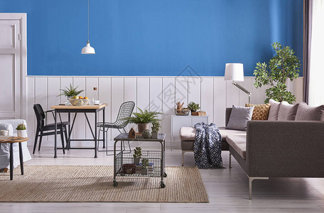现代餐厅装饰木桌和黑色椅子蓝色和白色的墙壁背景经典的墙壁细节灰色家具中桌沙发和蓝色扶手椅柳背景图片