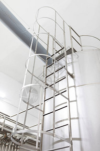 钢楼梯在厂房金属楼梯阳光下储油罐上的楼梯带铁图片