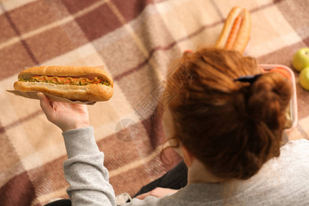 野餐时吃美味热狗的女人图片