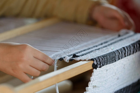 在木织机上织布的女人的手图片