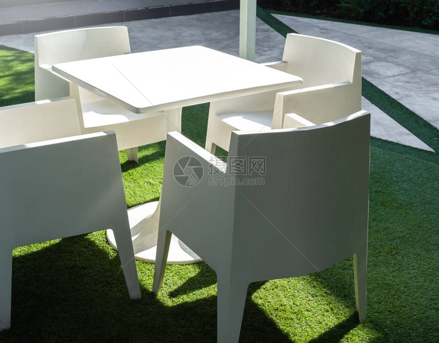 白色现代花园餐桌和绿色院子的四张椅子图片