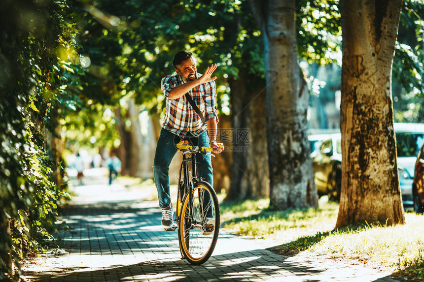 年轻的临时商人骑自行车去工作图片