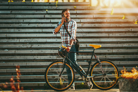 长胡子成年男子在自行车旁走路用图片