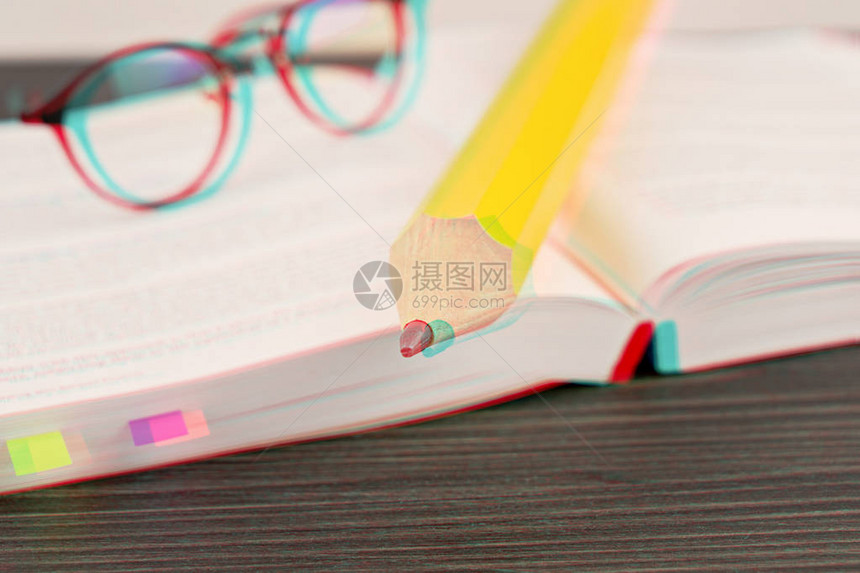 使用大黄铅笔在一本公开书上阅读眼镜的闪光效应野外浅深度和选择软焦点工作手册图片