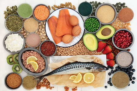 含有高蛋白鱼乳制品坚果种子豆类谷物膳食补充剂粉末和片剂蔬菜和水果的健美保健食品白色木背景图片